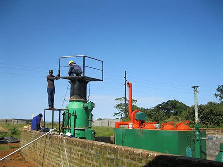 Technicians assembling a green biomass gasifier on a platform